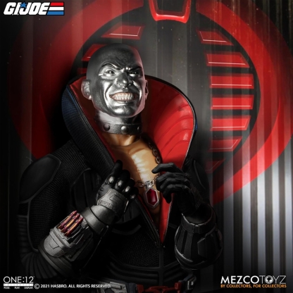 "Close-up portrait of the Mezco One:12 Collective Destro action figure, showcasing one of his interchangeable masked head sculpts with a subtle smirk, and details of his red-lined collar and necklace, against a red COBRA logo background."