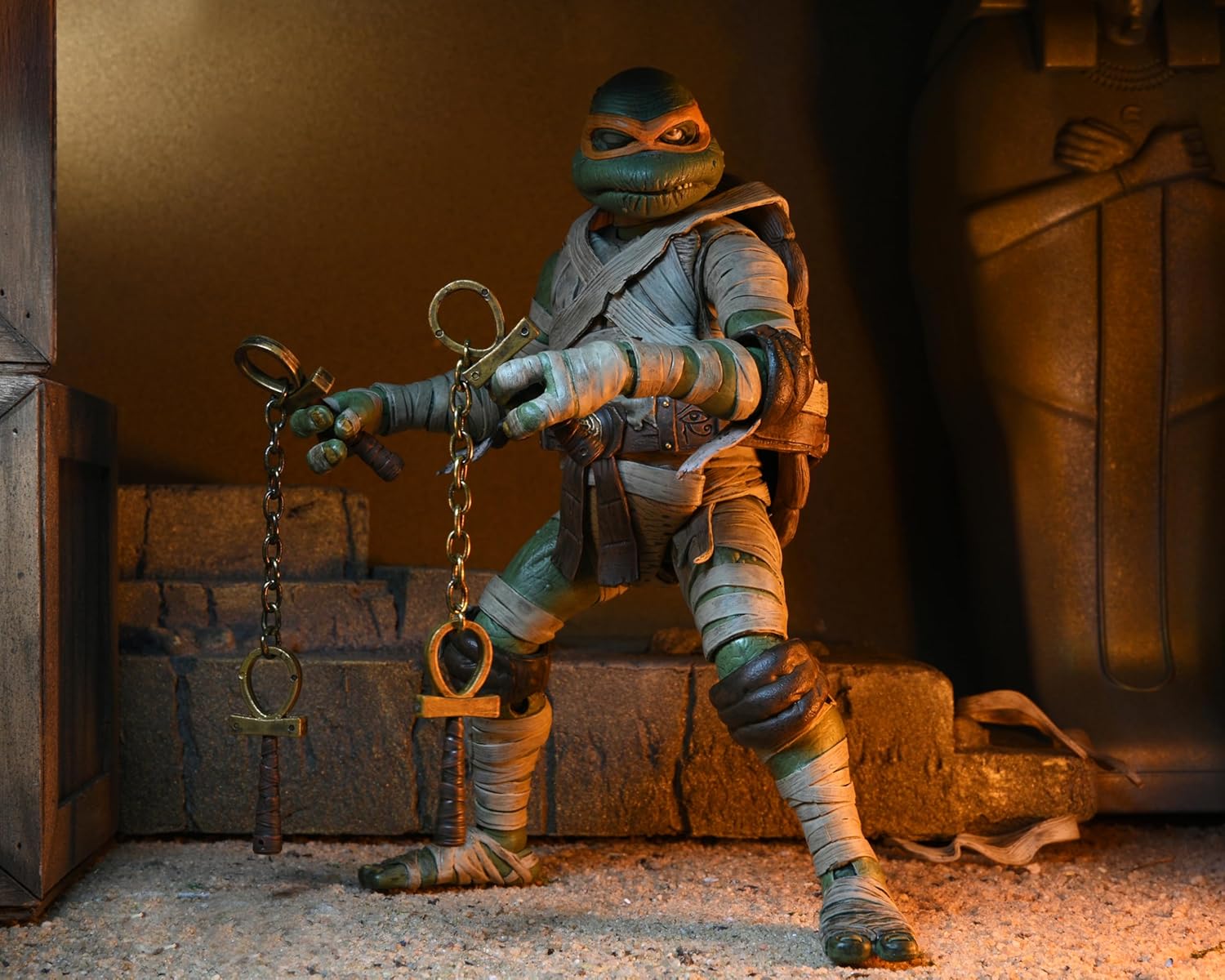 The 7-inch scale Michelangelo Mummy action figure posed with his unique cobra-headed nunchuks and ancient Egyptian-style shell.