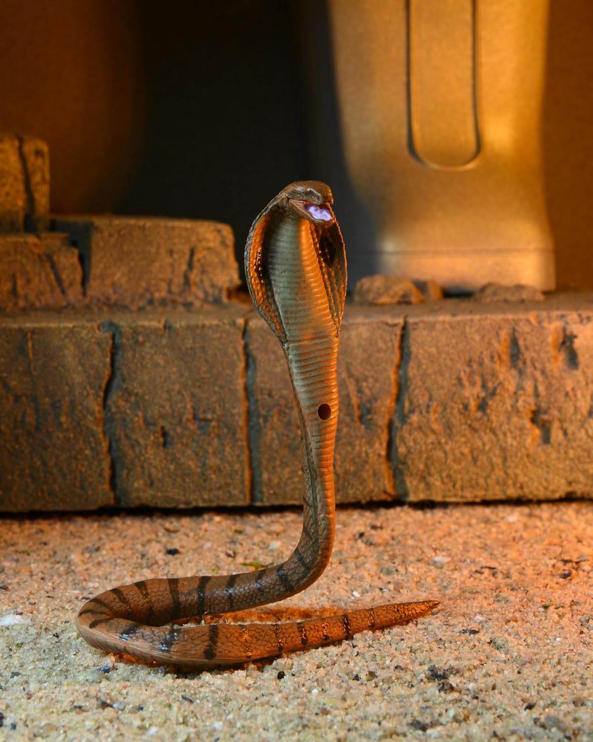 Detailed shot of the figure's accessories, including the swappable "screaming" head, extra hands, and the cobra-themed weapons.