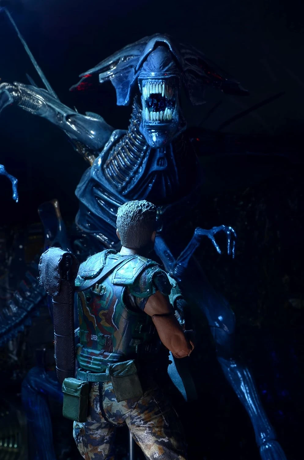 A massive, highly detailed 15-inch tall NECA Xenomorph Queen action figure with a glossy blue-black finish, displayed on a black support stand.